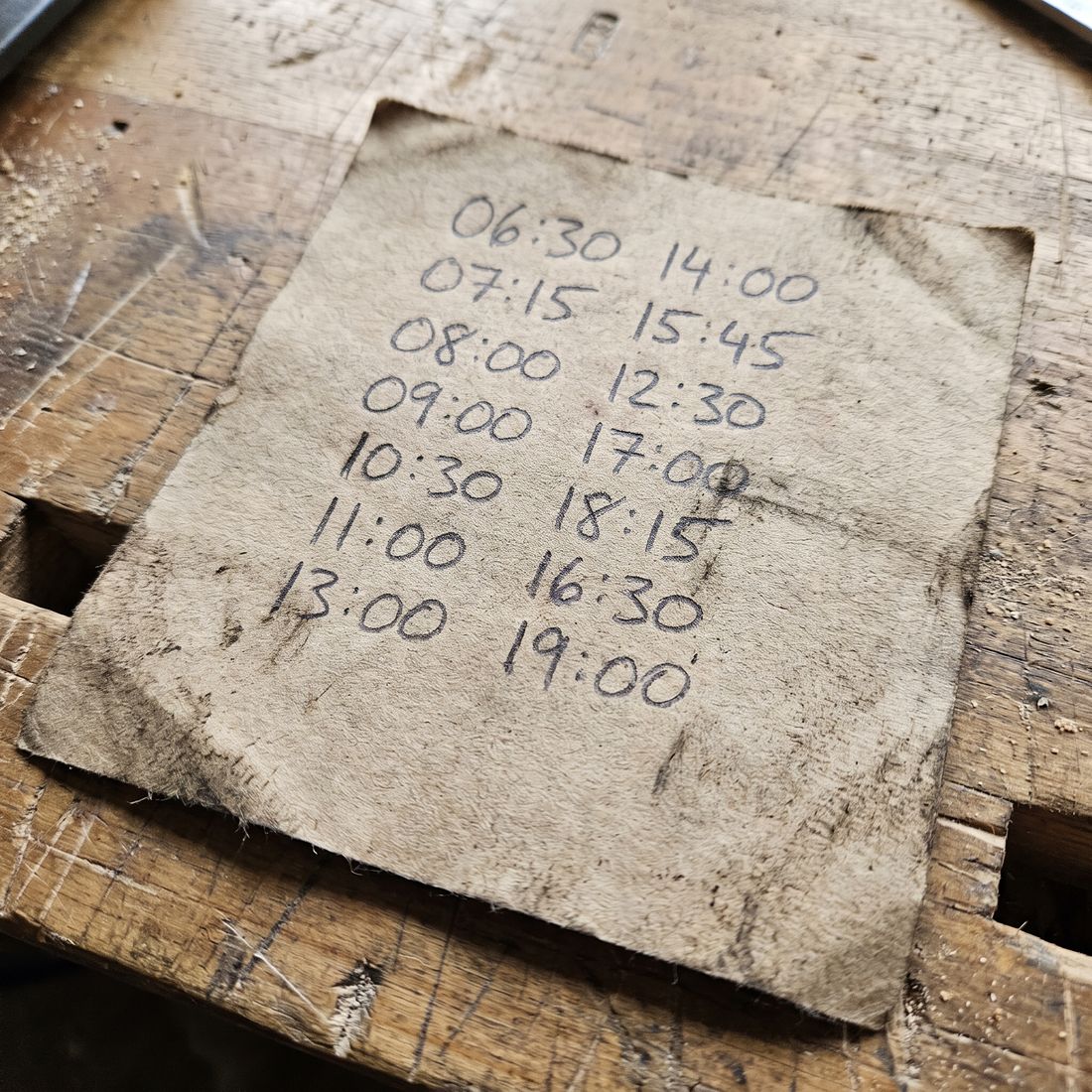 Handschriftlicher Zettel mit sieben Zeilen und je zwei Uhrzeiten